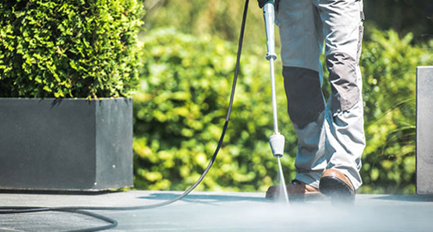 A workers completes a power washing services job.